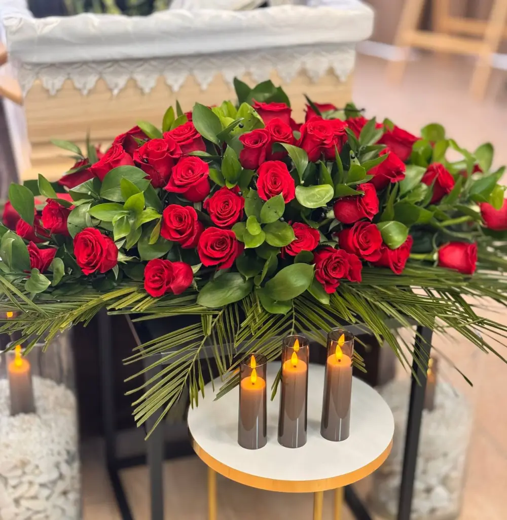Casket spray of red roses with greenery